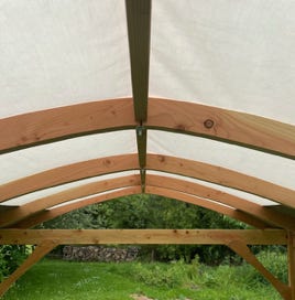 Structure intérieure de la tonnelle – faitage central et départ des chevrons cintrés pour une voûte harmonieuse et résistante.